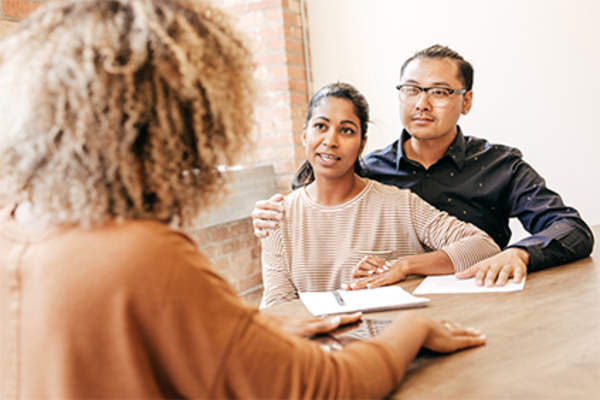 Young couple discussing fertility with their doctor.