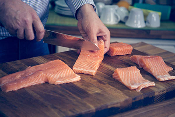 Man cutting a salmon filet.