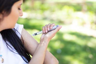 Injecting insulin in park.