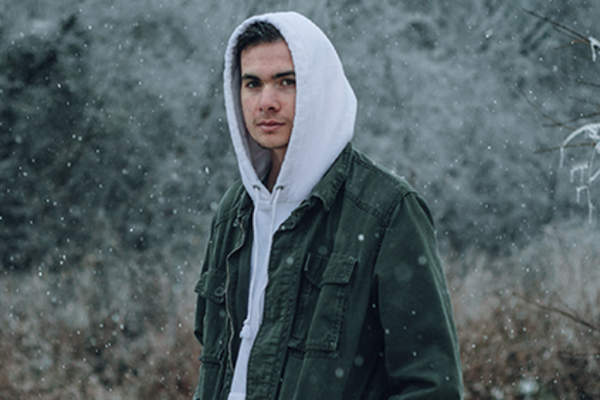 Somber man standing in the snow.
