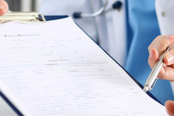 Doctor reminding patient to fill out current medication and supplements