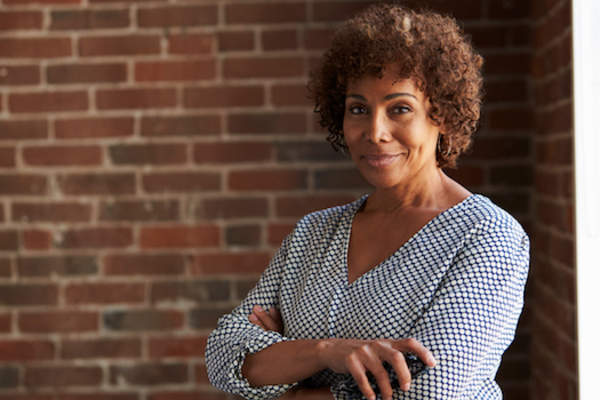 woman in front of brick wall