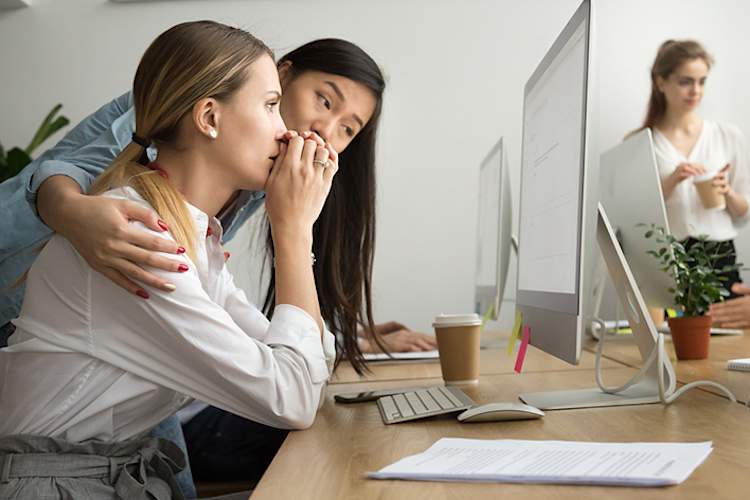 Woman supporting a female coworker in the face of bad news with a hug.
