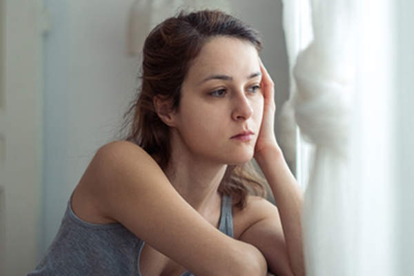 Depressed woman looking out the window.