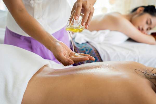 women receiving oil treatment at spa