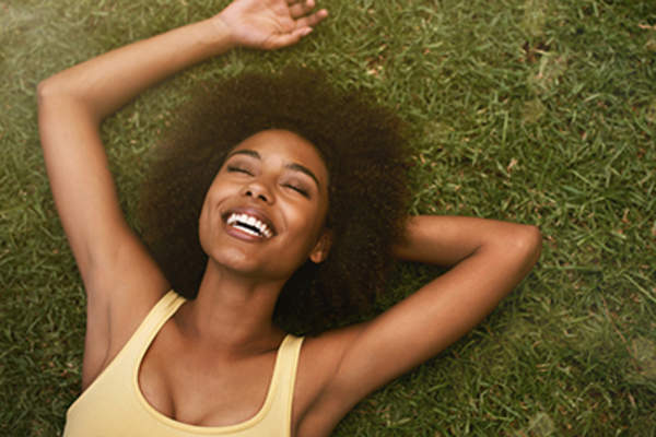 Woman laughing while laying in the grass.