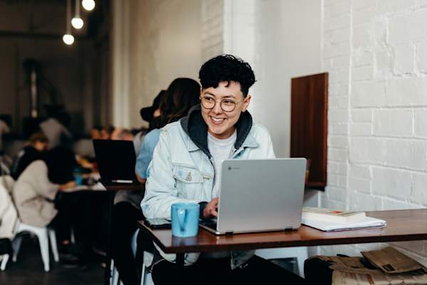 women smiling in cafe on laptop