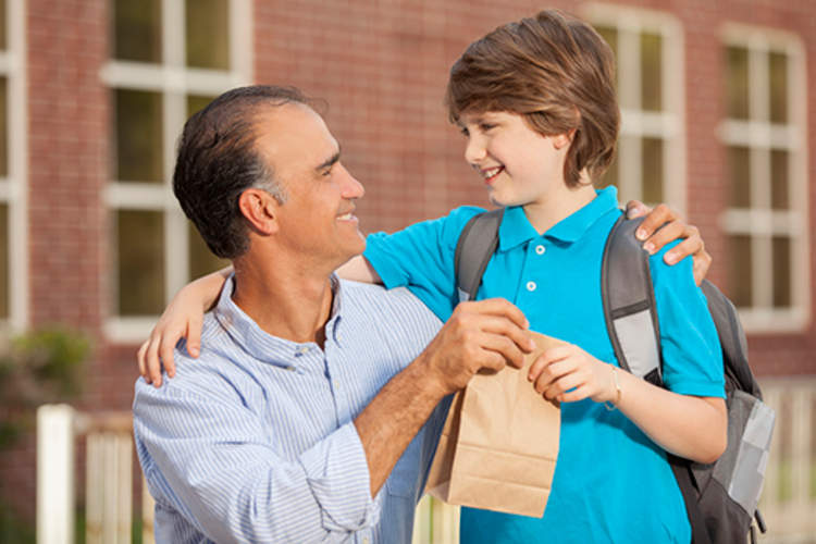 A father sending his son to school with a healthy lunch.