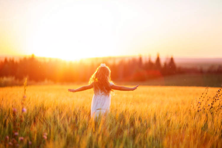Young girl in field at sunset.