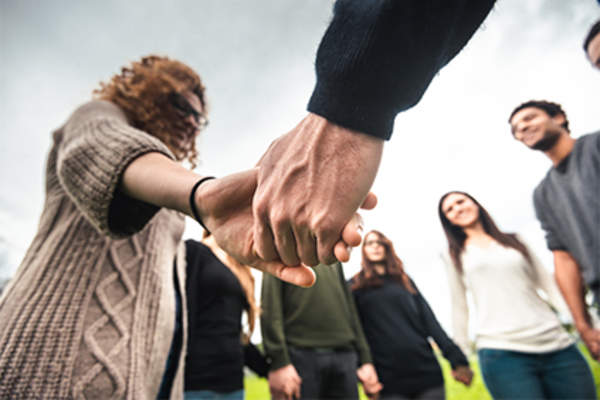Supportive group of friends holding hands.