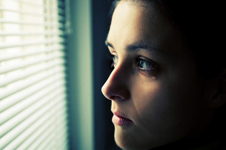 young woman crying looking out window image