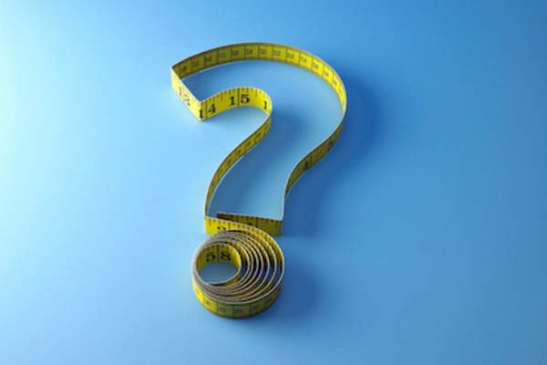 Body image question concept, measuring tape shaped like question mark.