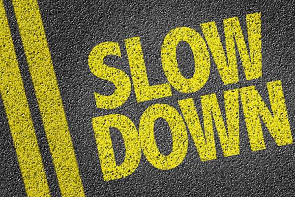 "SLOW DOWN" painted on road.