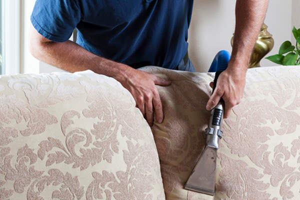man vacuuming couch image