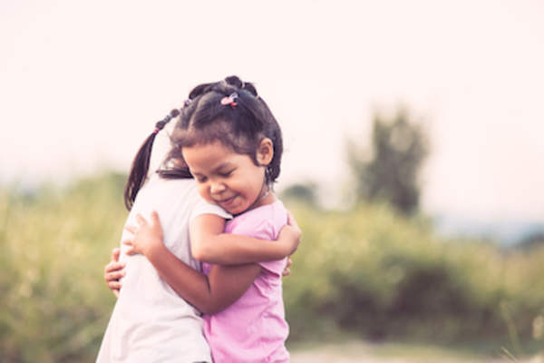 Two young girls hugging.