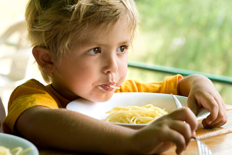 Little boy eating spaghetti