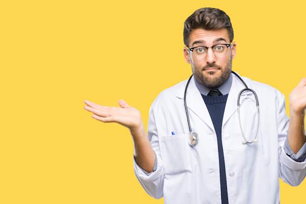 Doctor clueless and confused expression with arms and hands raised. Doubt concept.
