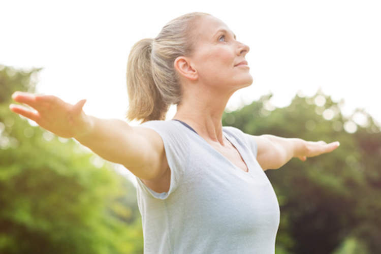 Middle aged woman stretching outside.