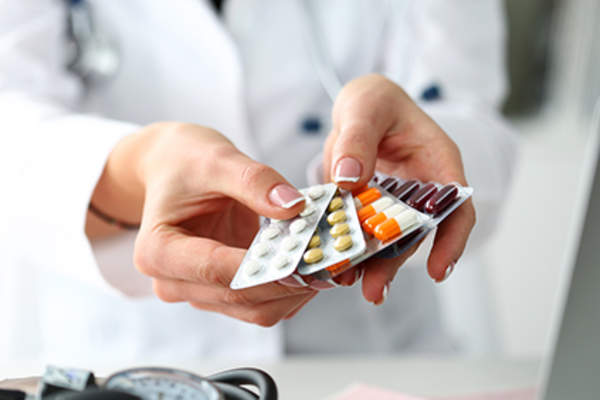 Doctor holding various medications.