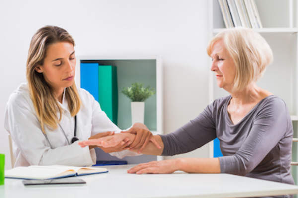 Woman talking to doctor about joint pain.