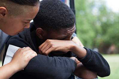 Young man supporting an emotional friend.