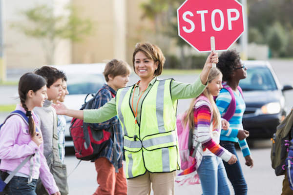 Children walking across street on way to school.
