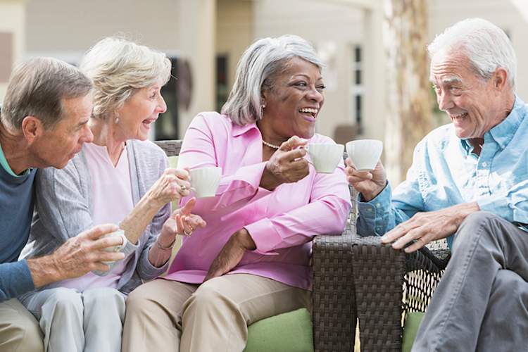 Group of seniors talking, laughing, and drinking coffee.