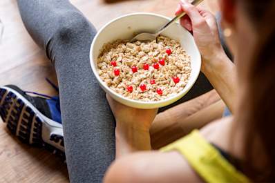 Woman eating breakfast before exercising.