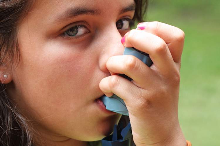 Girl using asthma inhaler.