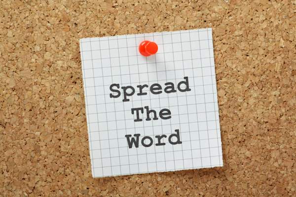 Spread the word note tacked to corkboard.