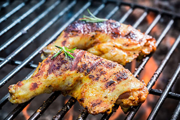Roasted chicken legs on the grill with fire