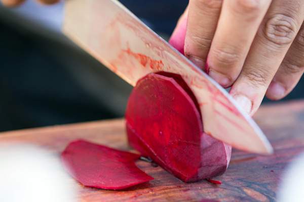 man's hands cutting beets