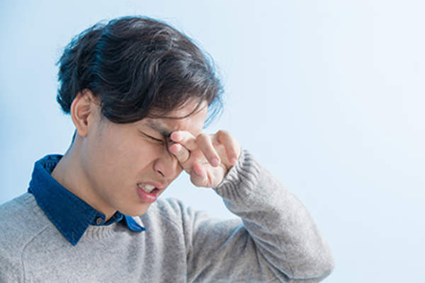 Young man with severe eye pain.