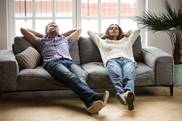Couple relaxing on couch at home.