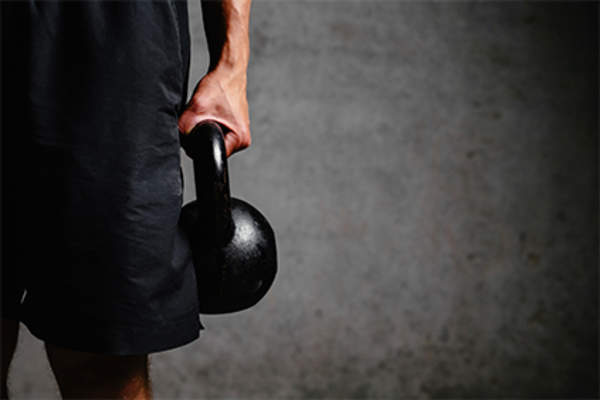 Man holding a kettle weight.
