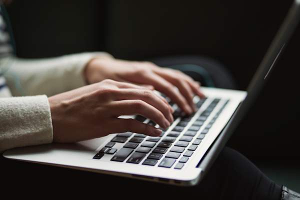 Woman's hands typing on laptop