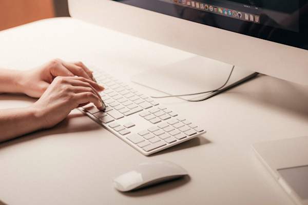 woman's hands typing on computer keyboard