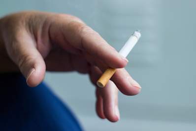 Hand with burning cigarette.