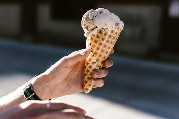 Hand holding melting ice cream cone