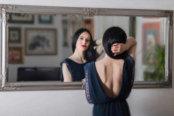 Looking in mirror, body image concept.
