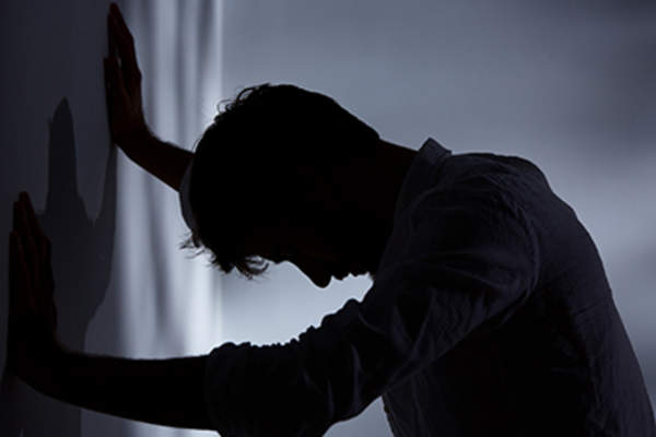 Man in pain in dark room.