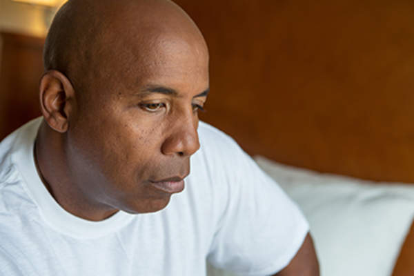 Sad man sitting on the bed.