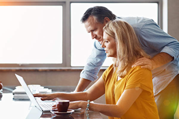 Adult couple working on laptop at home.