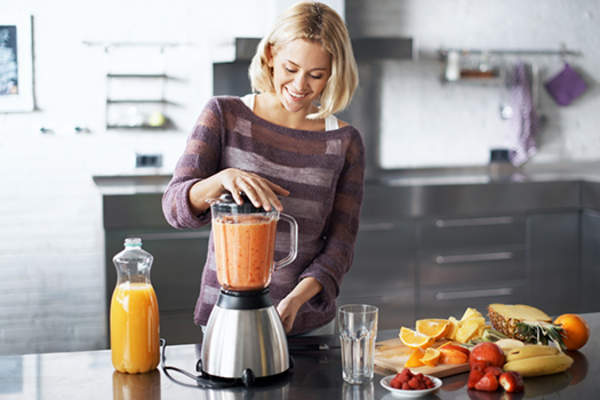 Woman making a smoothie at home image.