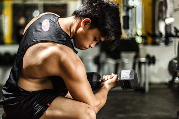man flexing lifting dumbbell