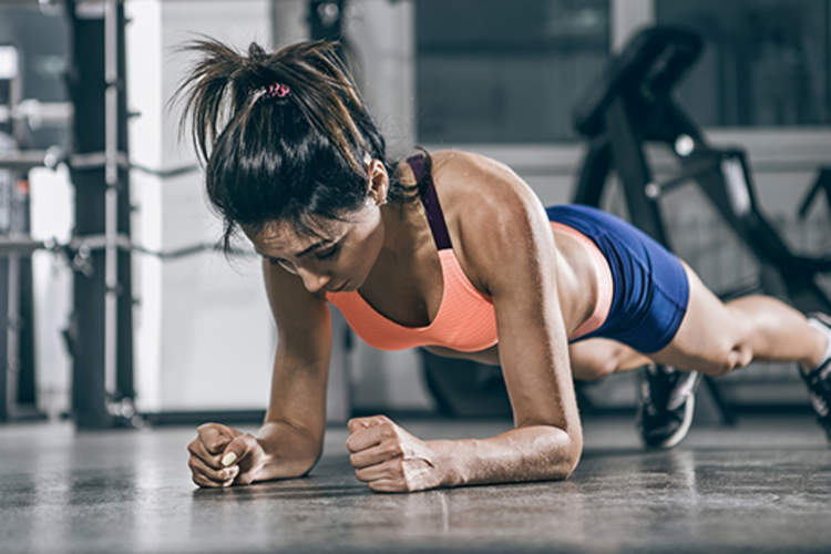 Muscular woman in a plank position