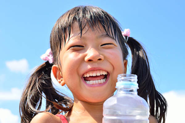 Laughing young girl with water bottle.