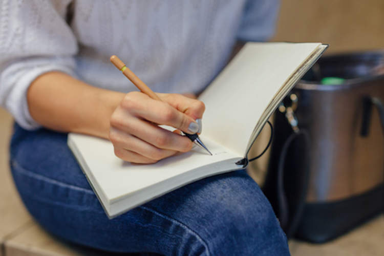 Woman journalling, to help with anxiety.
