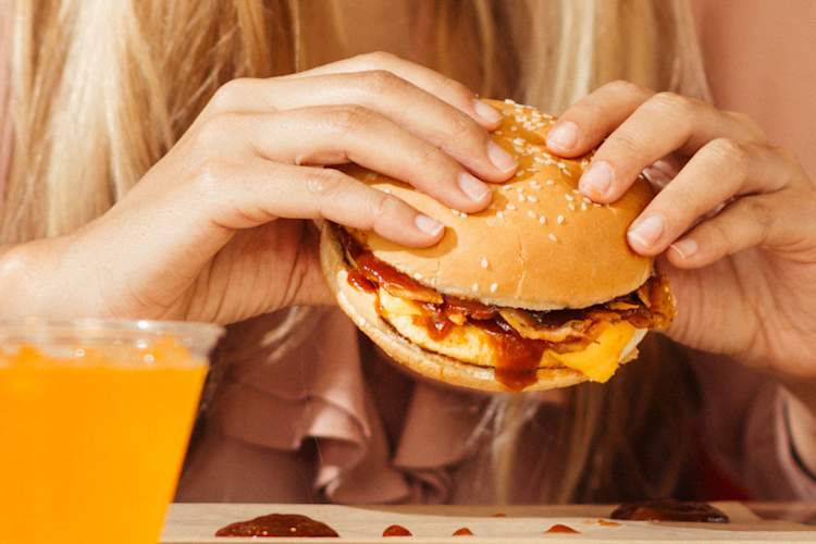 woman's hands eating burger