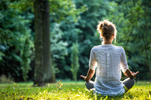 Woman meditating outdoors.